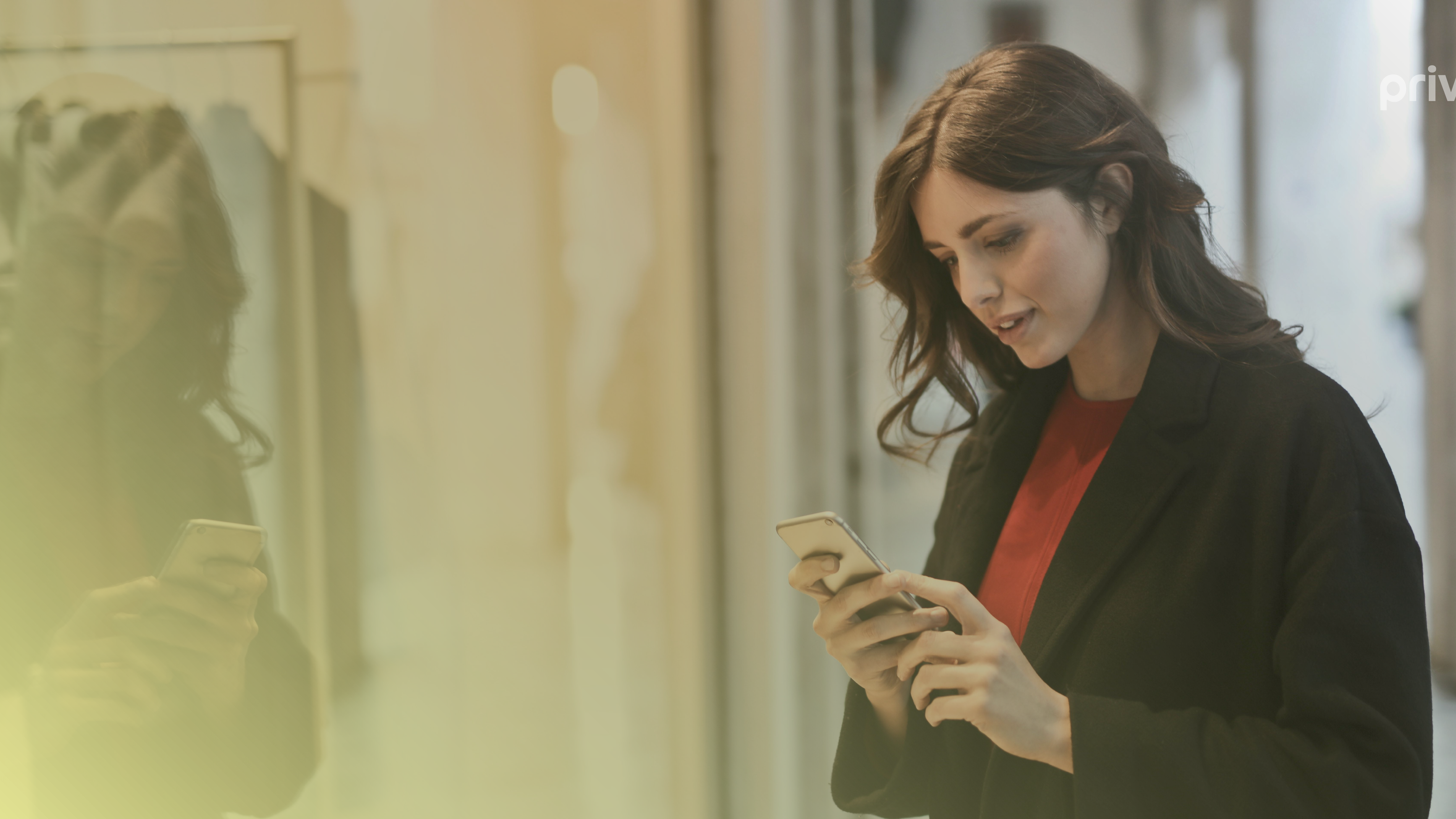 A woman in a black coat staring at a mobile device