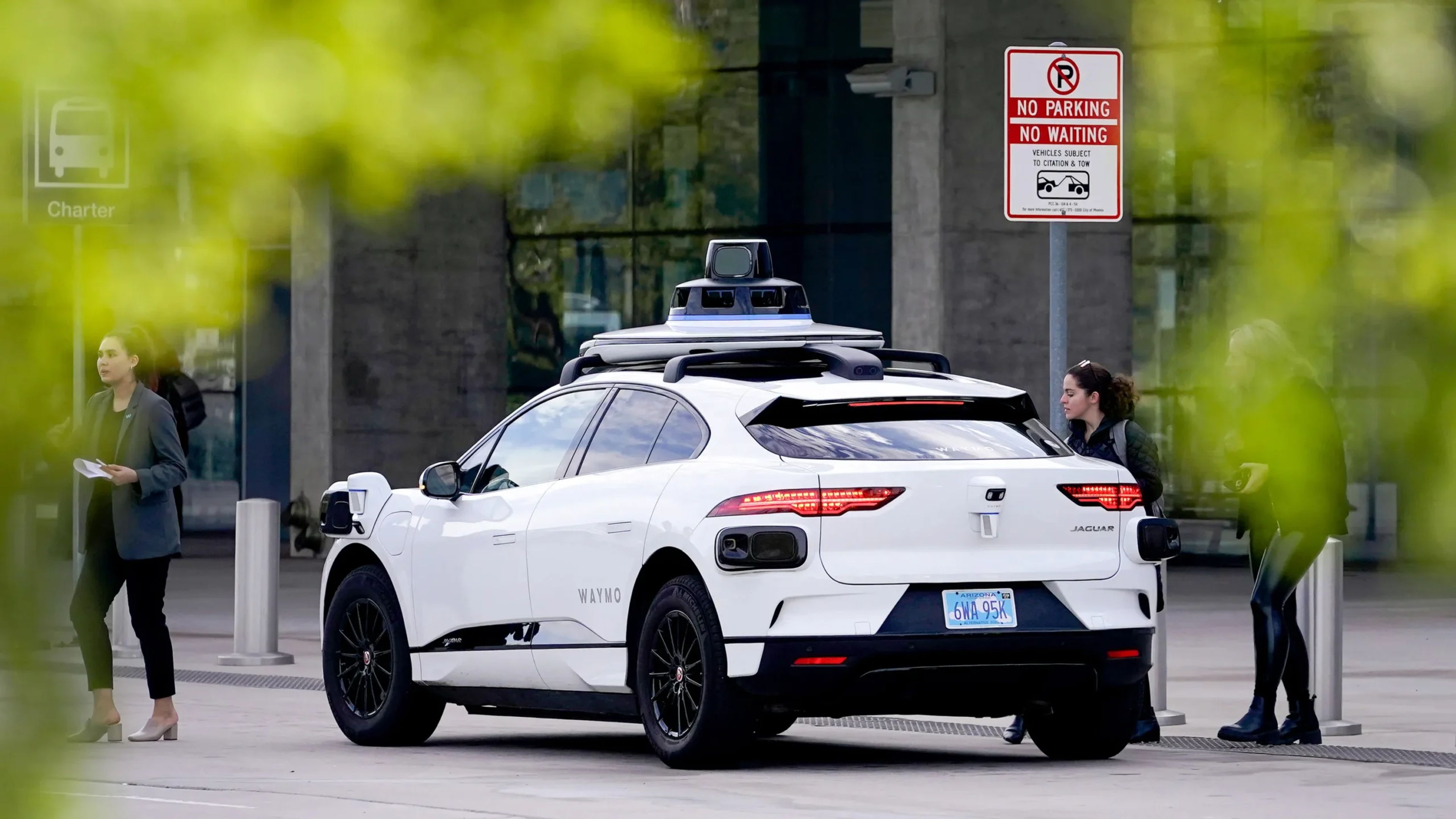 A sleek autonomous vehicle branded with Uber logos cruising through an urban environment, showcasing futuristic transportation.