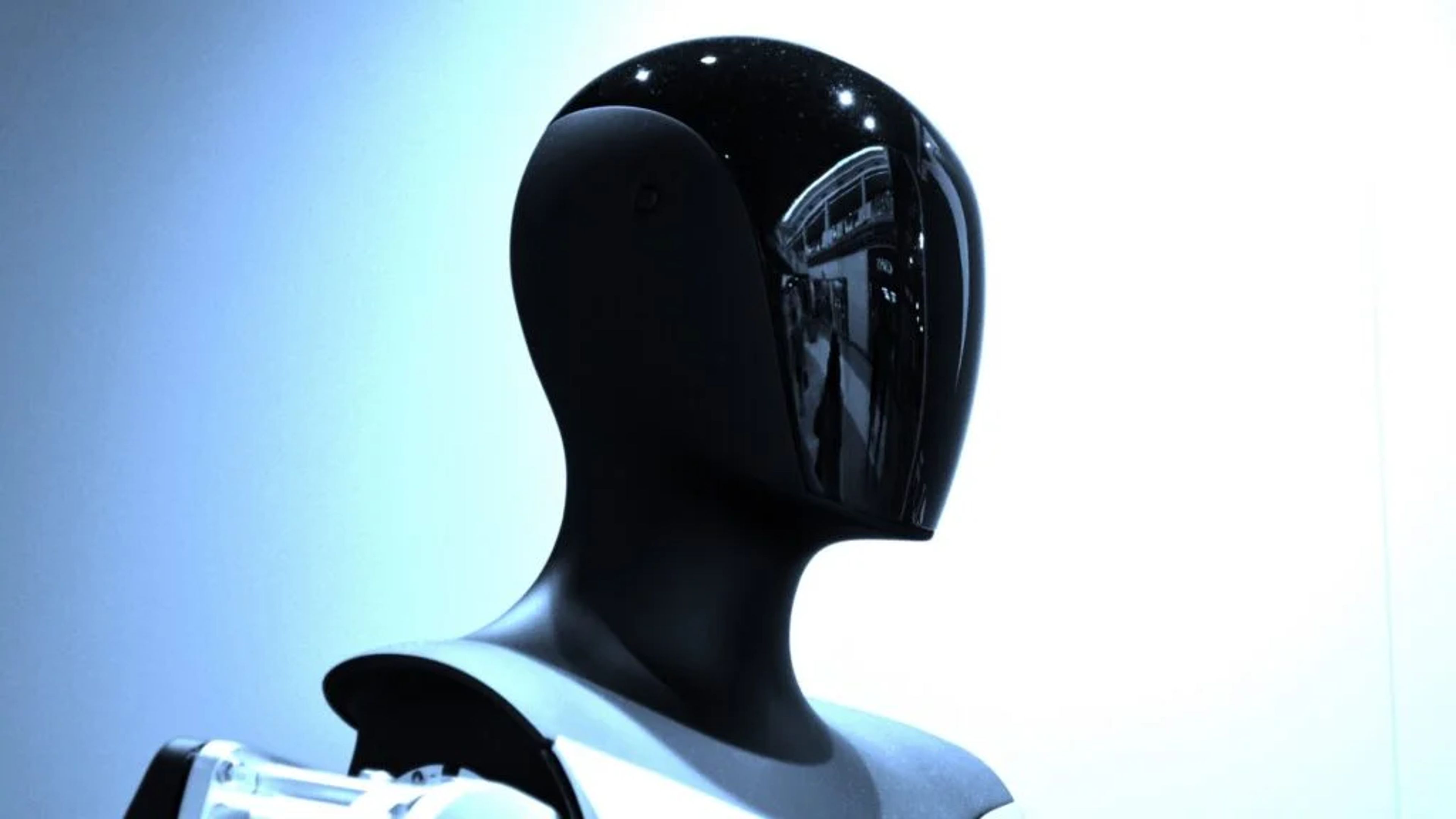 Tesla’s Optimus robot prototype in a sleek lab setting, paired with a profile image of Milan Kovac, symbolizing innovation and leadership transition.