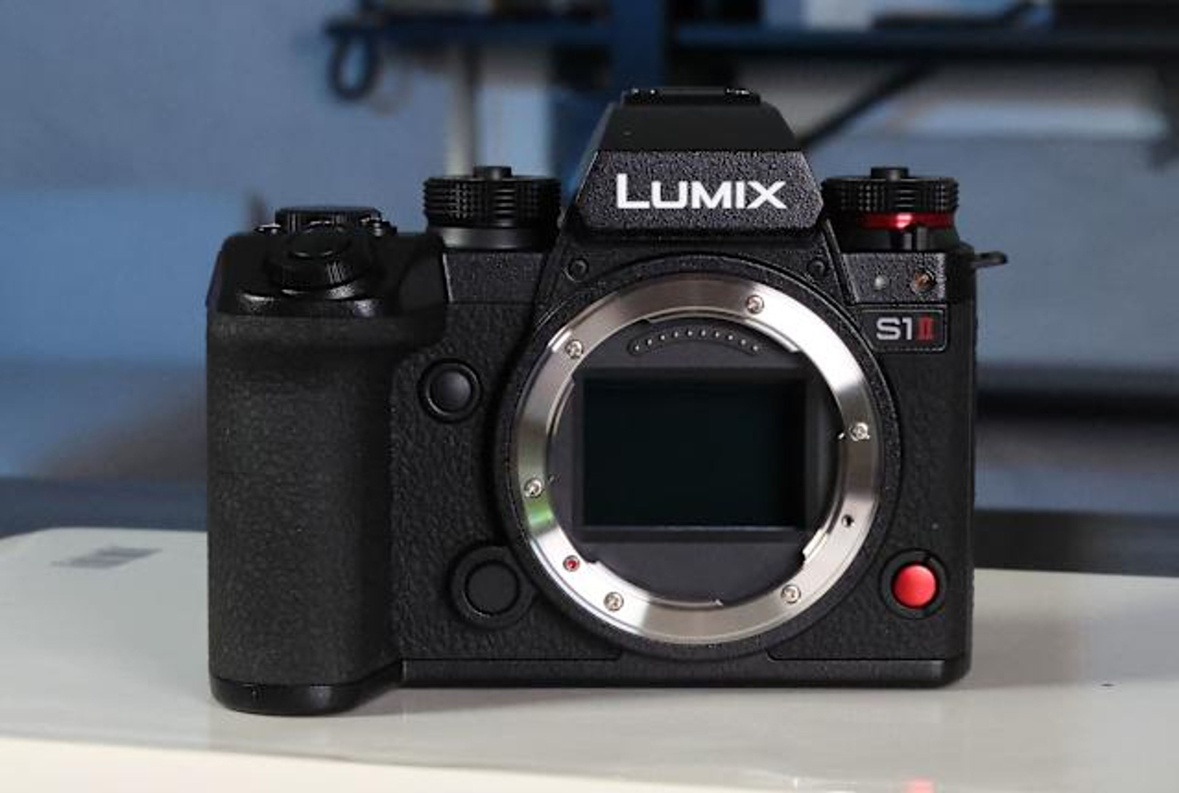 Panasonic Lumix S1 II camera mounted on a tripod, capturing high-resolution video content in a studio setup, with external monitor and lighting visible.