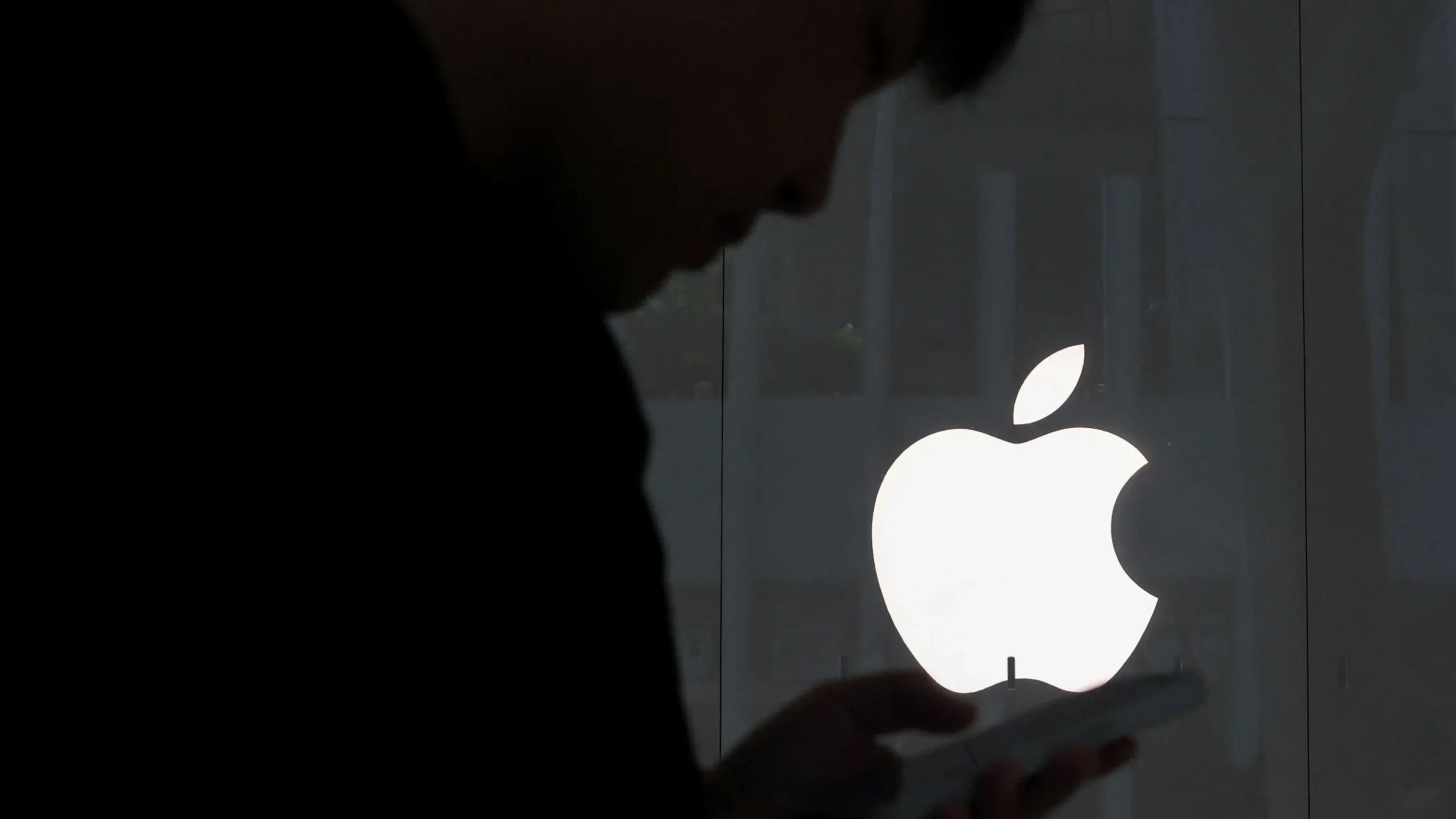 Excited attendees and developers gather around a glowing Apple logo, with WWDC 2025 graphics on screen teasing new innovations.