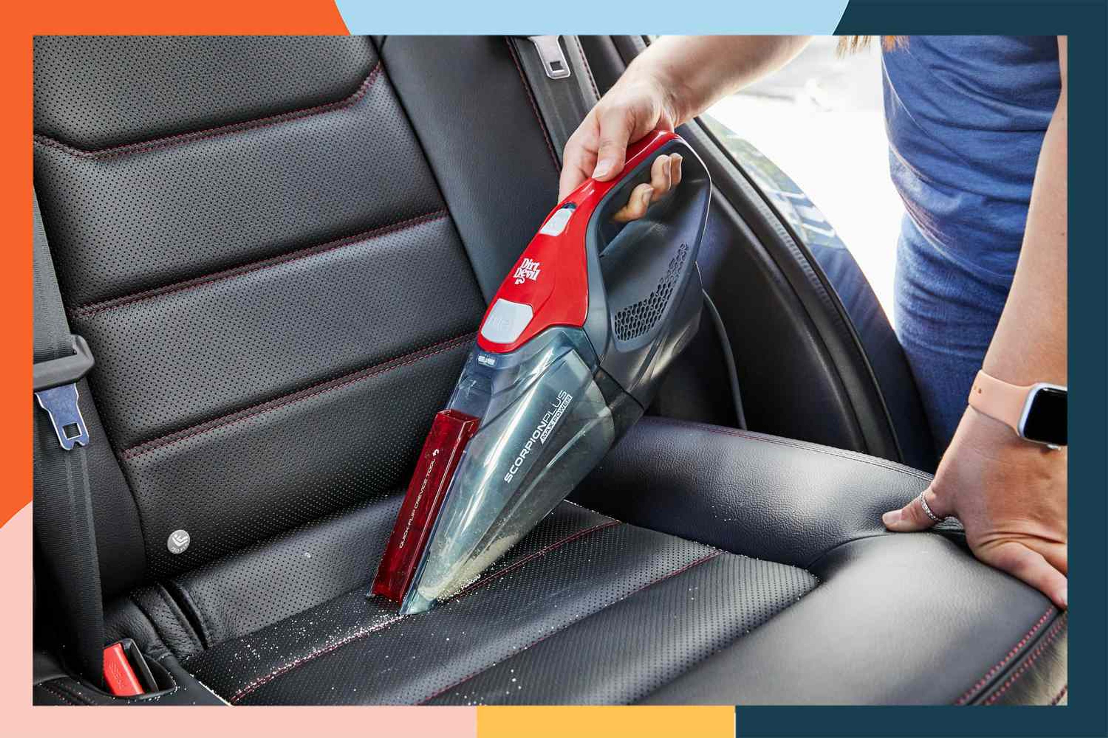 A modern handheld car vacuums cleaning a car interior, with visible crumbs and dust being suctioned from tight spaces.