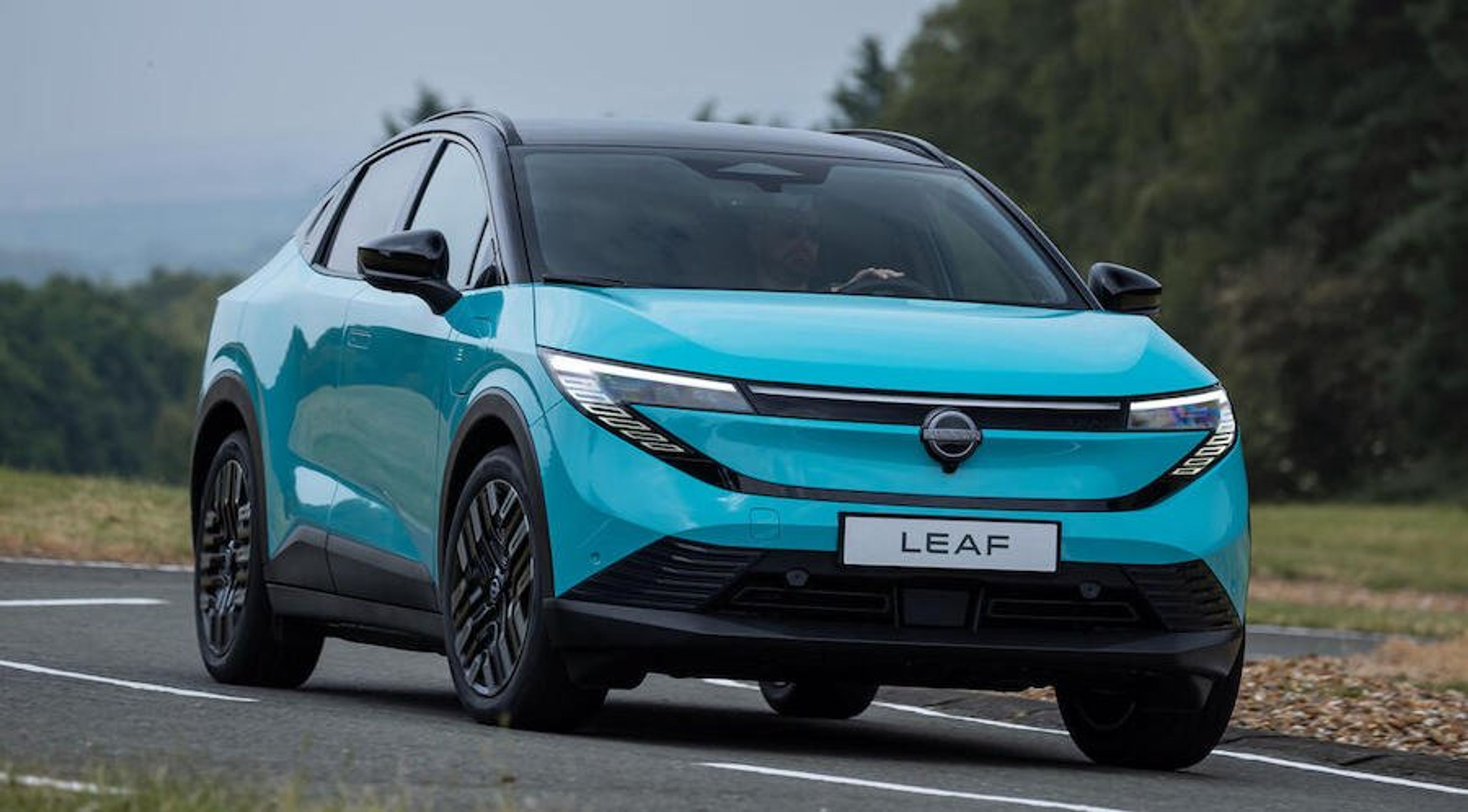 The 2026 Nissan Leaf cruising through a scenic urban backdrop, with aerodynamic design lines and EV indicators highlighting its refreshed comeback.