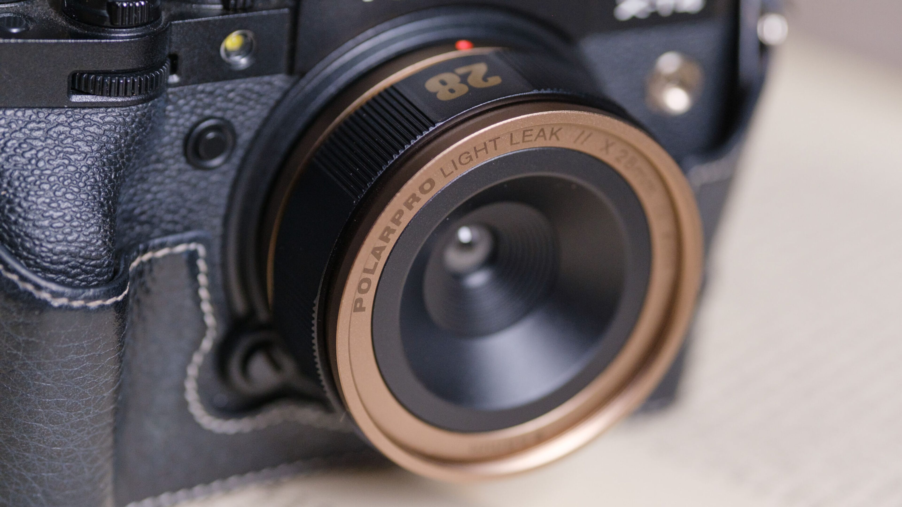 A mirrorless camera fitted with the PolarPro Light Leak lenses, capturing dreamy, retro-style flares in a golden-hour portrait setup.