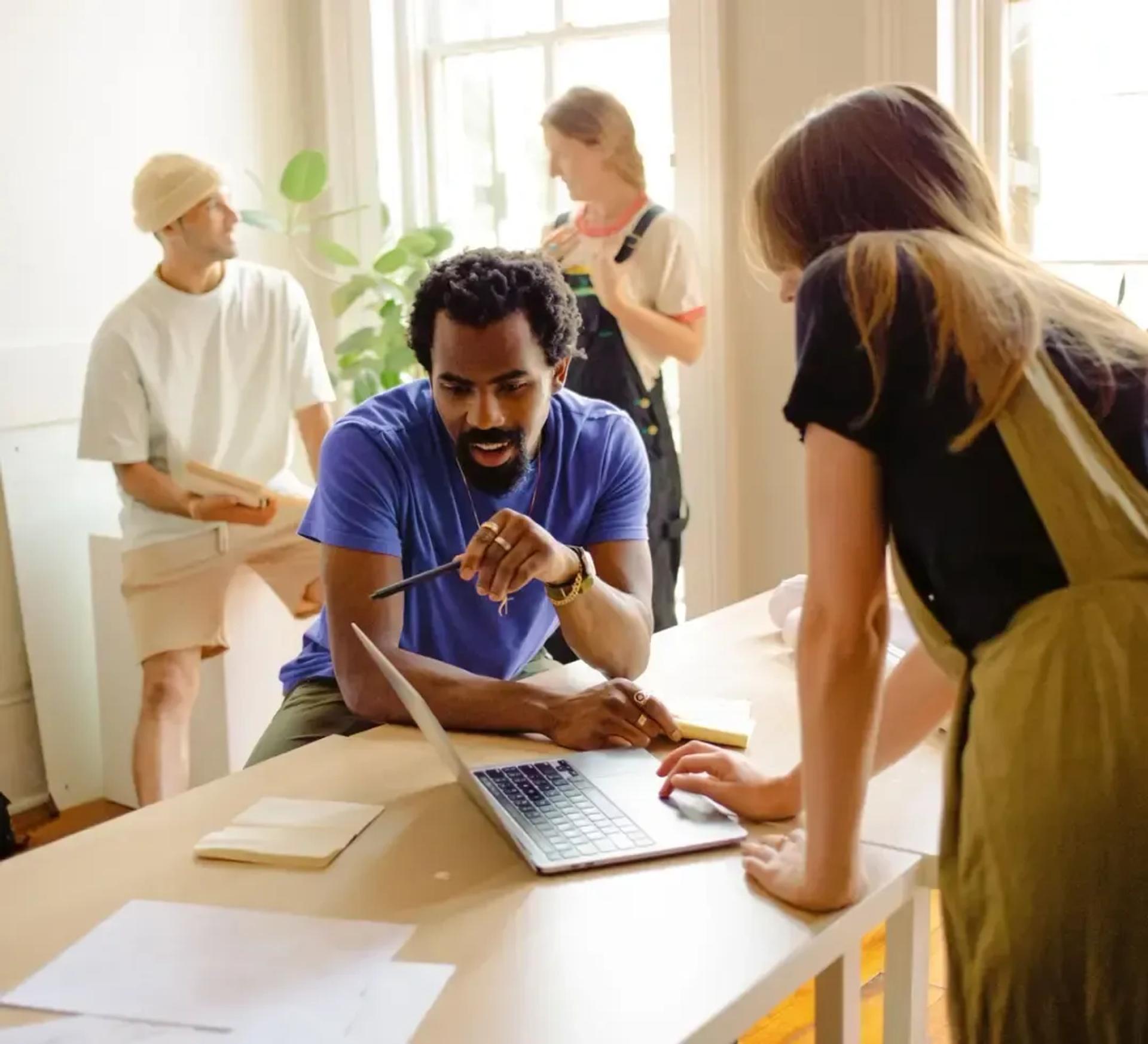 4 employees working together at a standing table