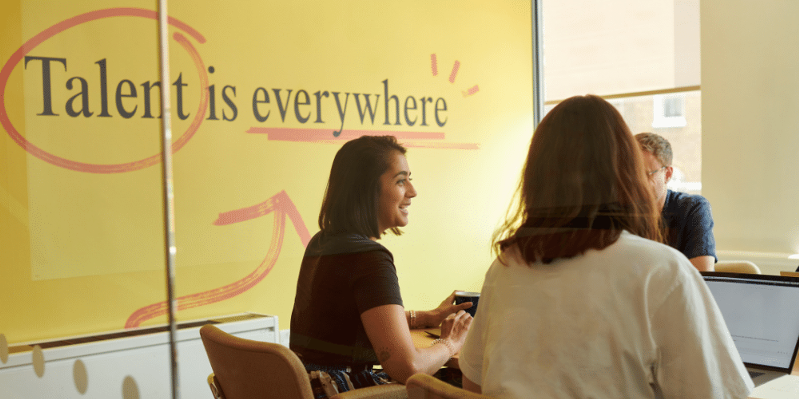 Three people in a meeting room