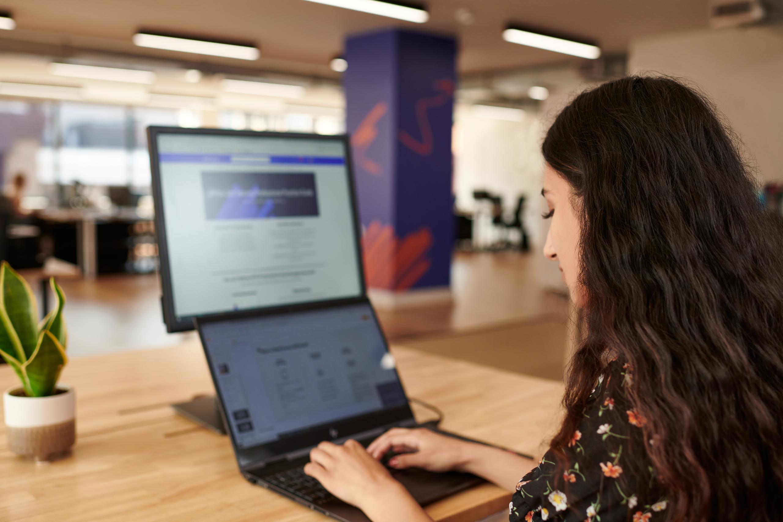 A woman working on a laptop in the office