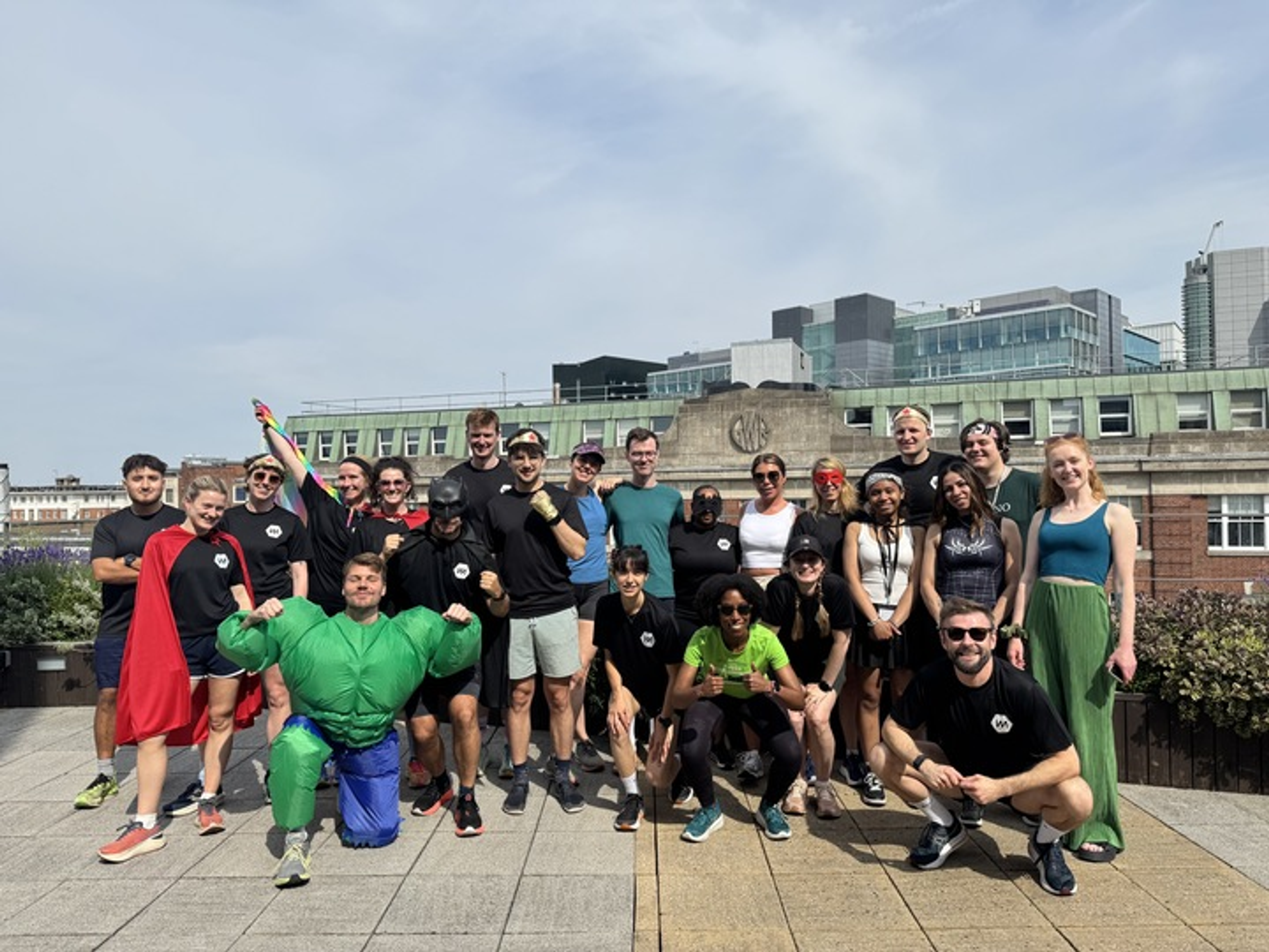 Employees in fancy dress on the balcony after a fun run.