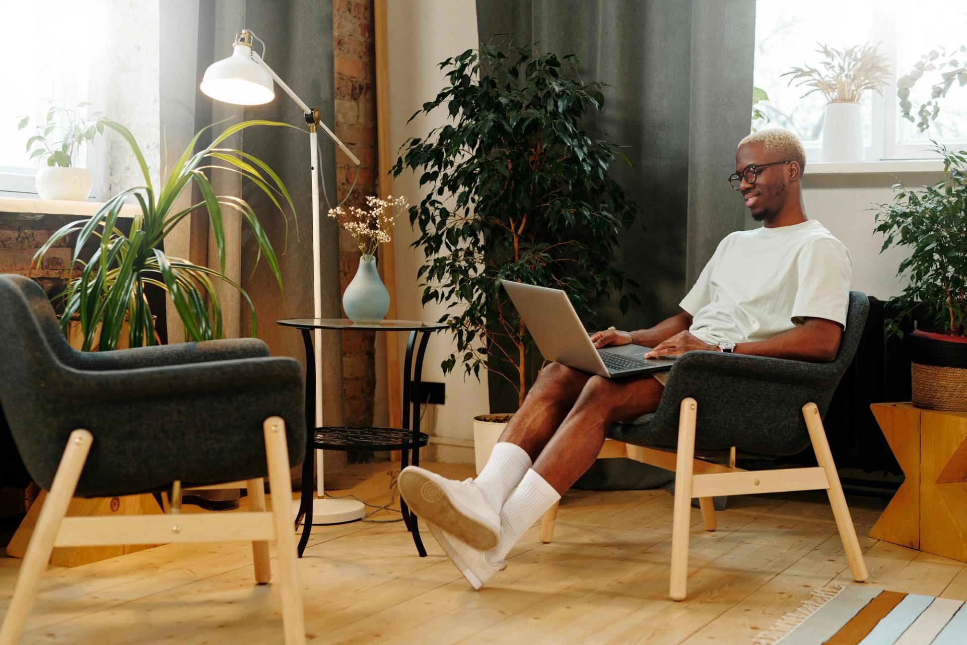 A man sitting, working on a laptop