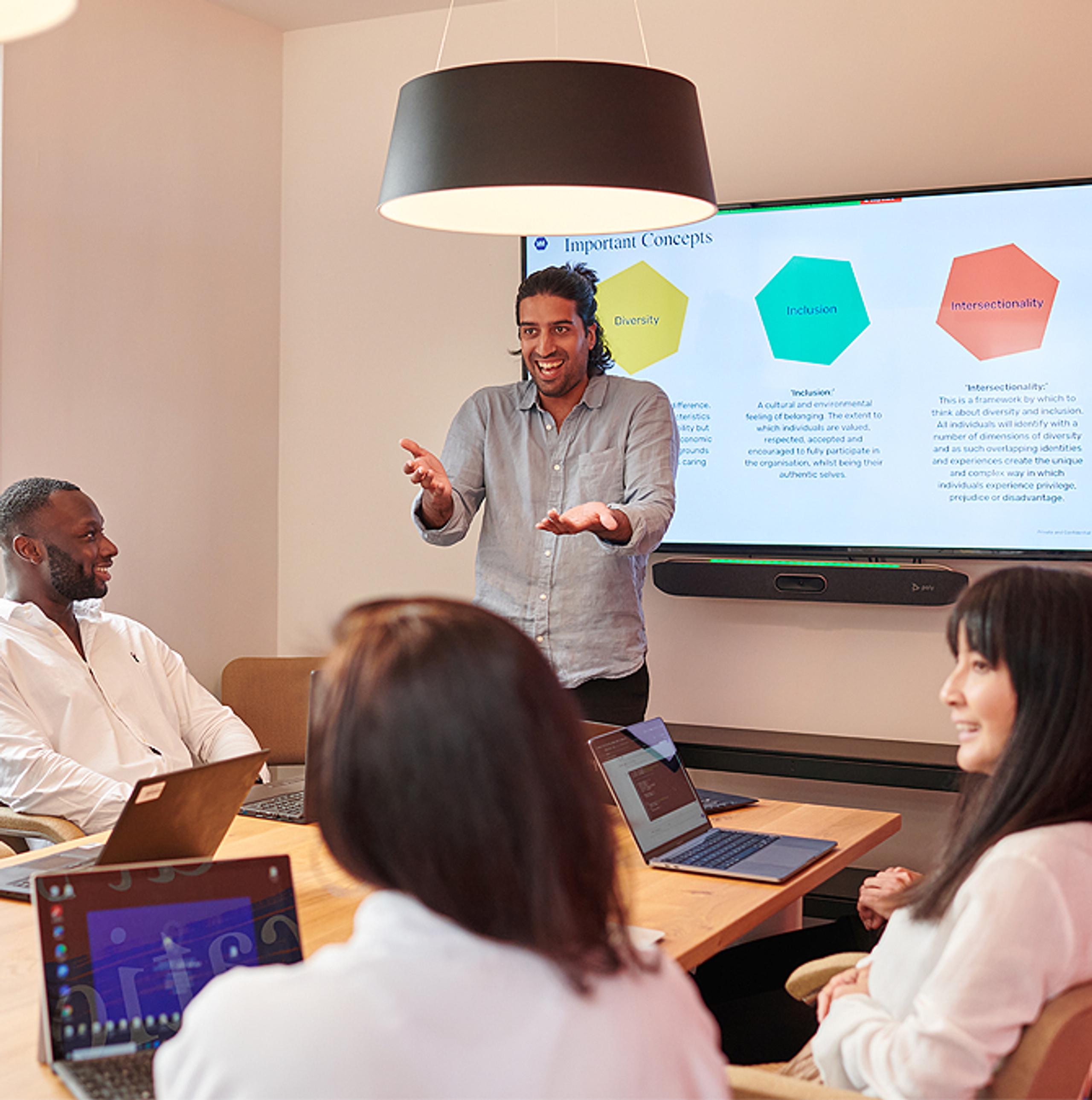 Man presenting to a group of smiling employees 