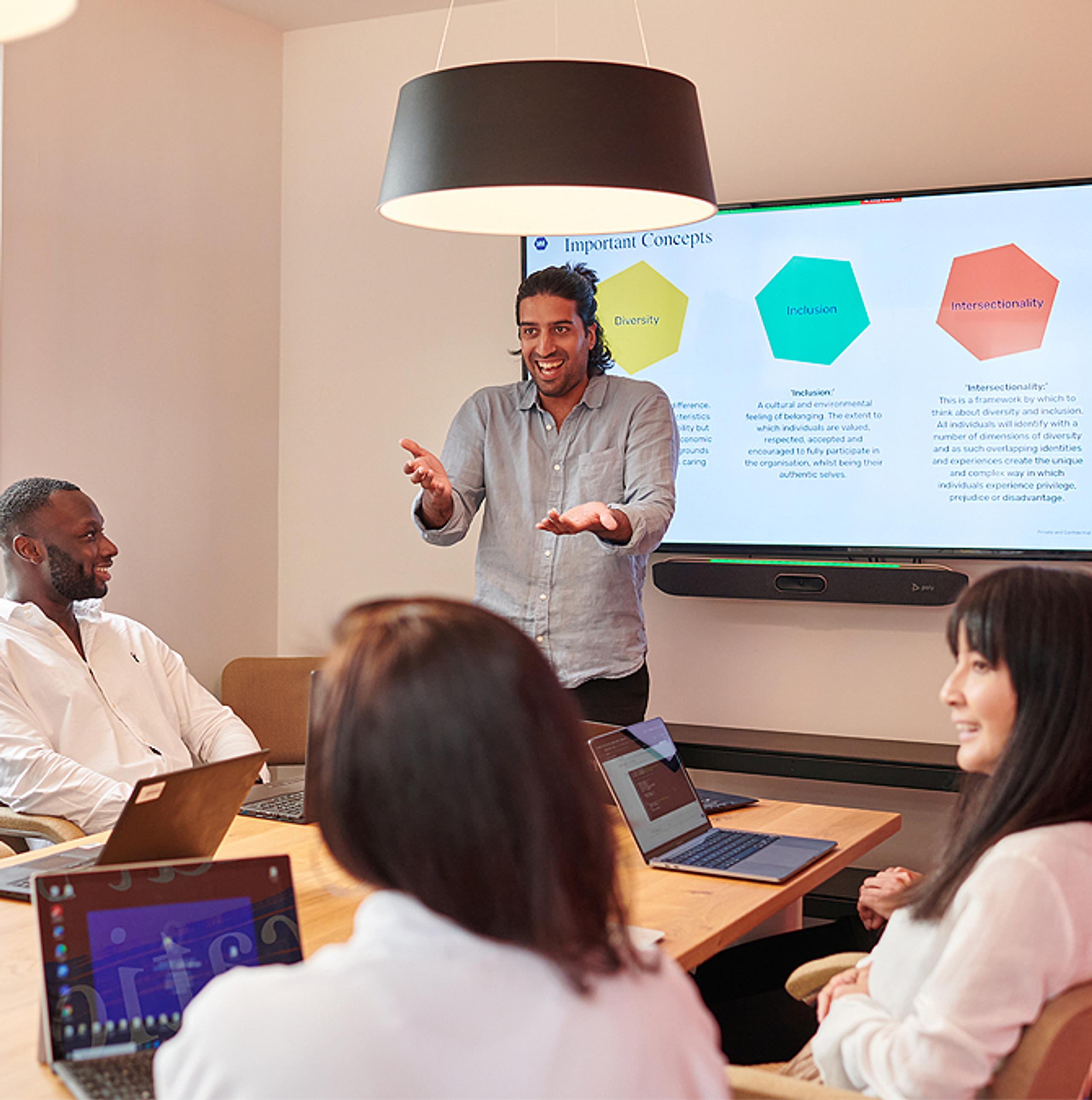Man presenting to a group of smiling employees