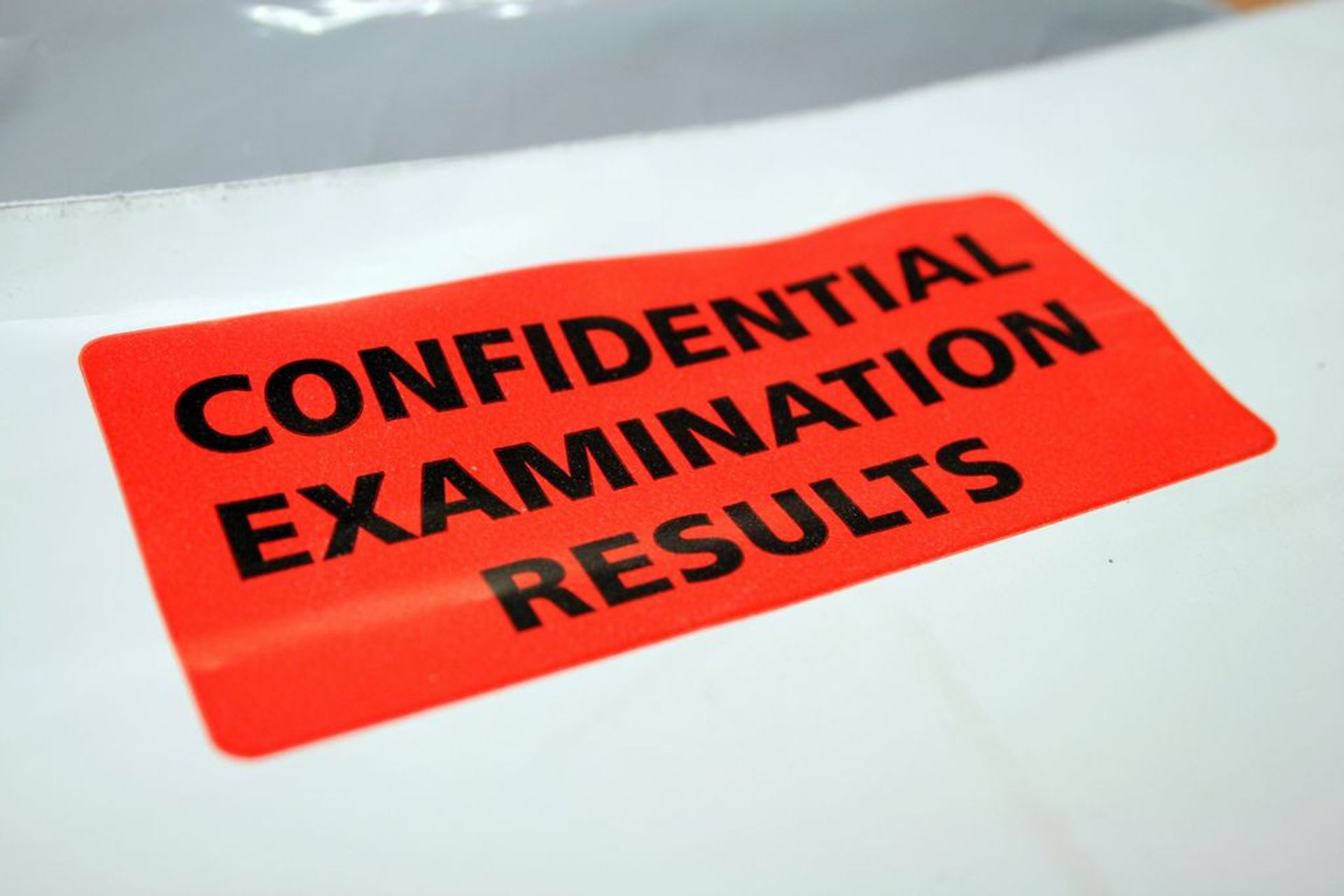 Text: "Confidential Examination Results" on a sign