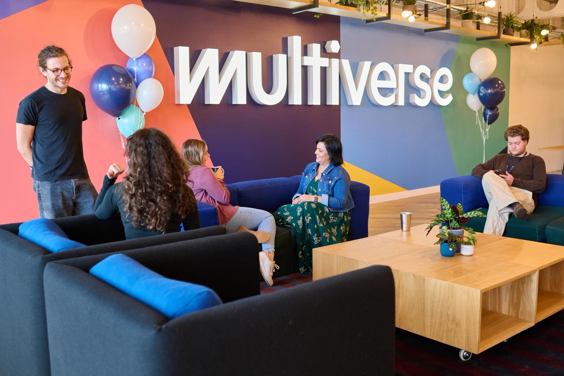 Employees chatting in a breakout space with large Multiverse Branding