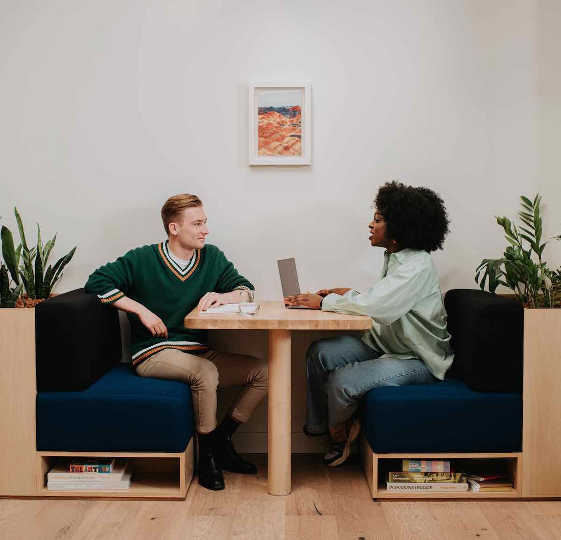 two people sitting at a desk in a coworking space