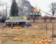 A firefighter picks out pumpkins in a field while a house is burning in the background