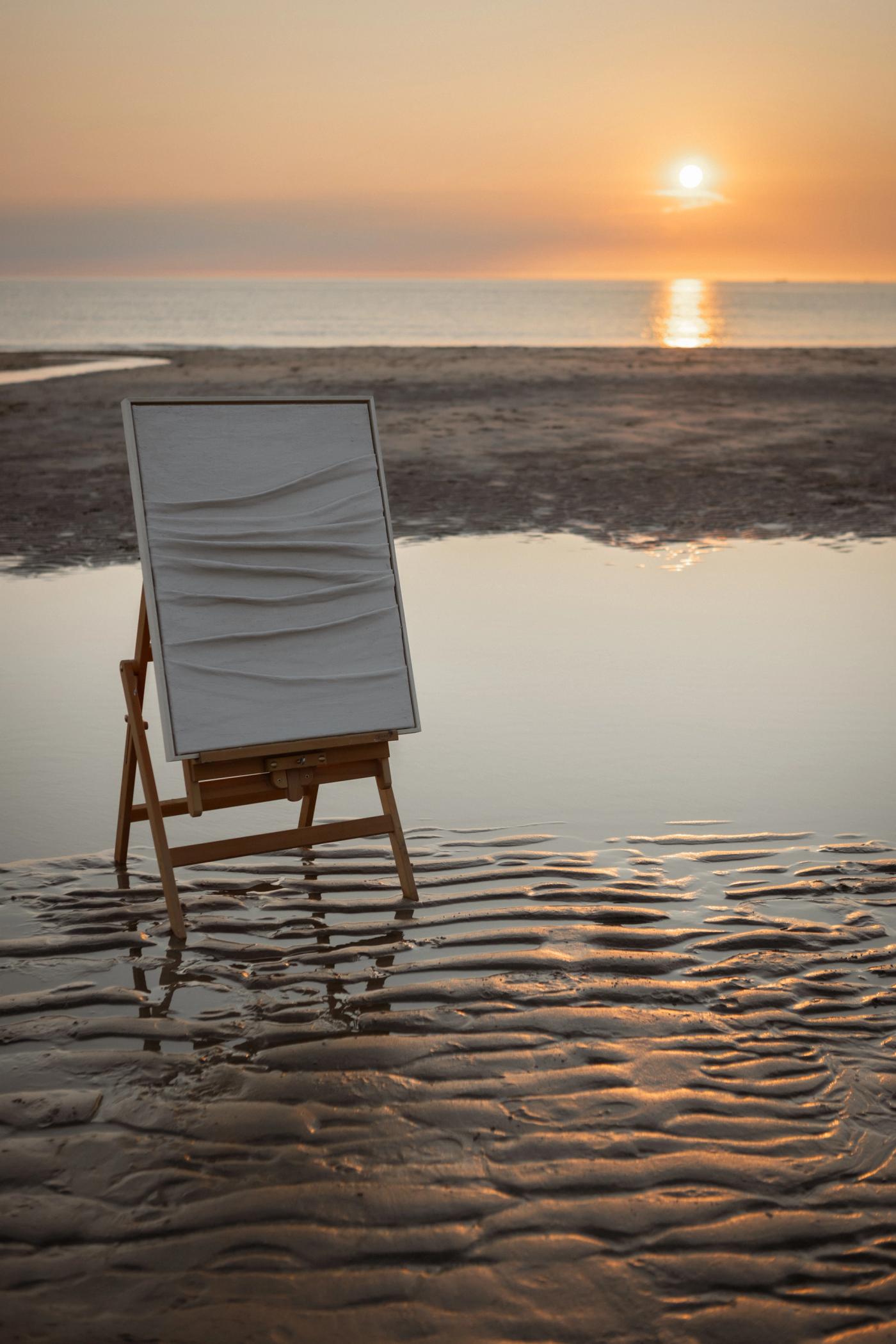 Ilse de Vries met werk op het strand, gouden uur
