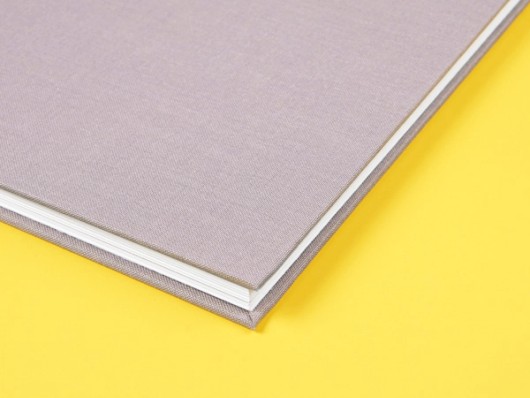 Premium Hardcover-Fotobuch auf gelbem Hintergrund