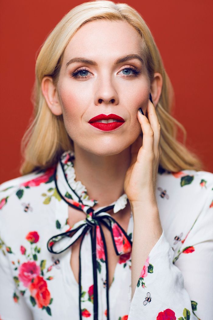 Erin Cornell in a floral blouse against a red backdrop