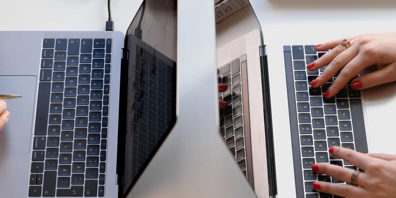 Two computer laptops on a white desktop