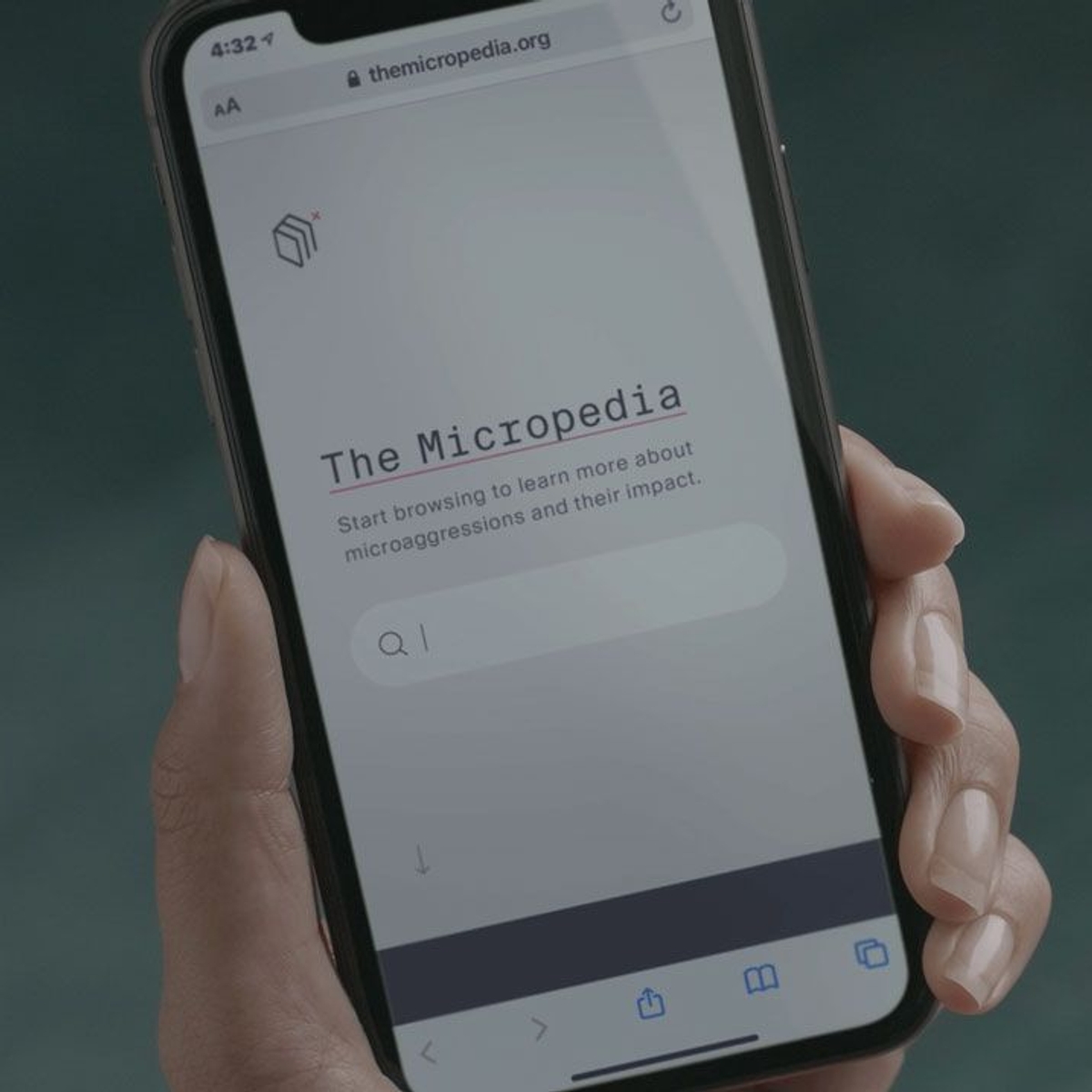 A hand holding a phone displaying the Micropedia of Microaggression website.