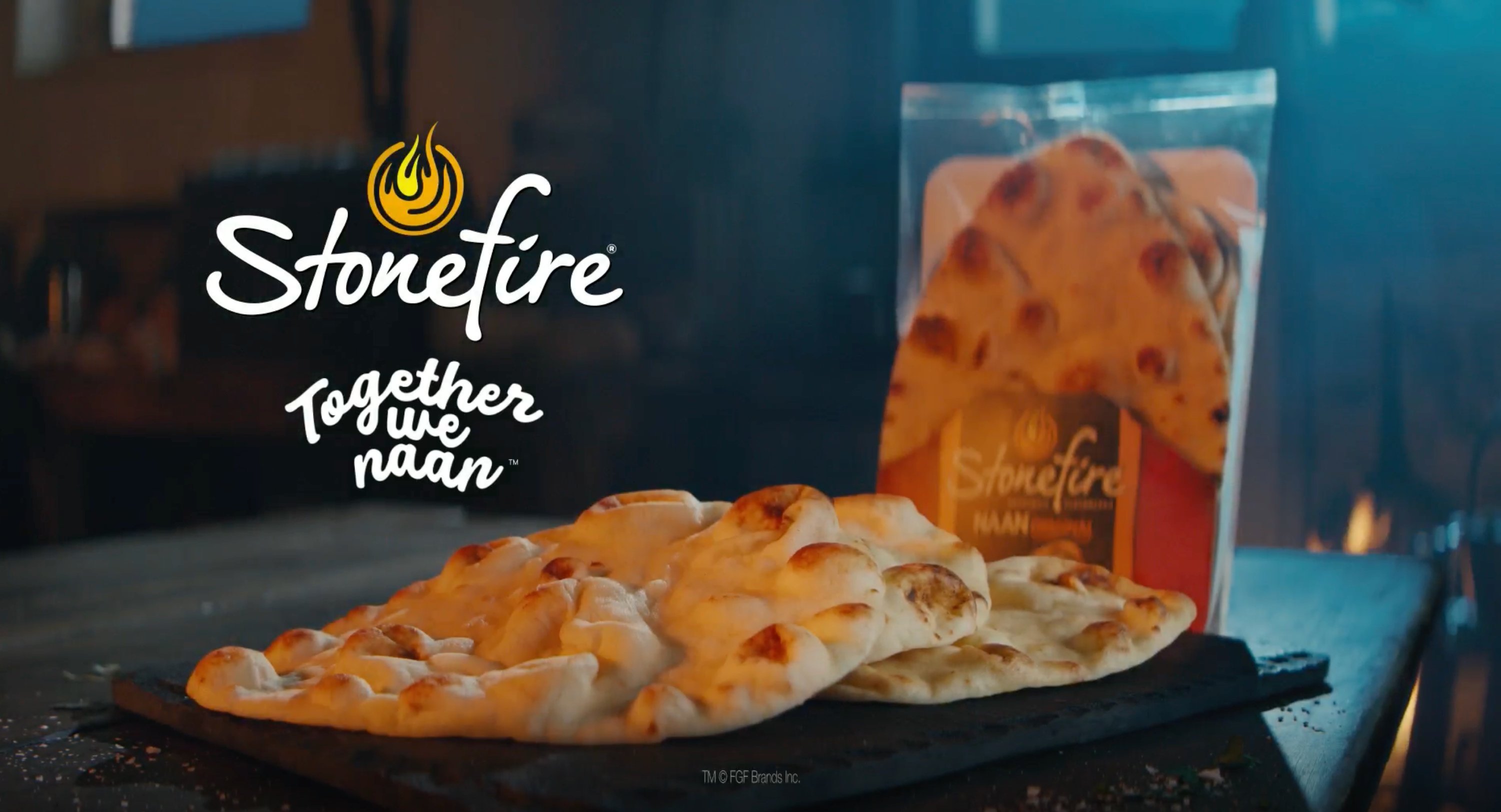 A pack of Stonefire naan bread is showcased on a rustic table with several pieces of naan laid out.