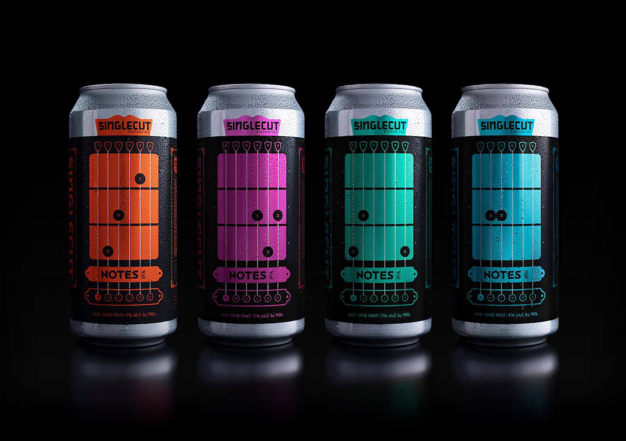 Four Notes IPA cans displayed against a black background, each featuring basic chords and finger positions.