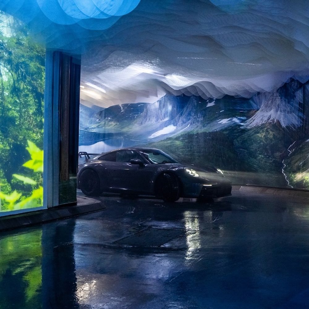A car driving into a carwash that has been transformed into an immersive, interactive experience showcasing beautiful imagery from British Columbia.