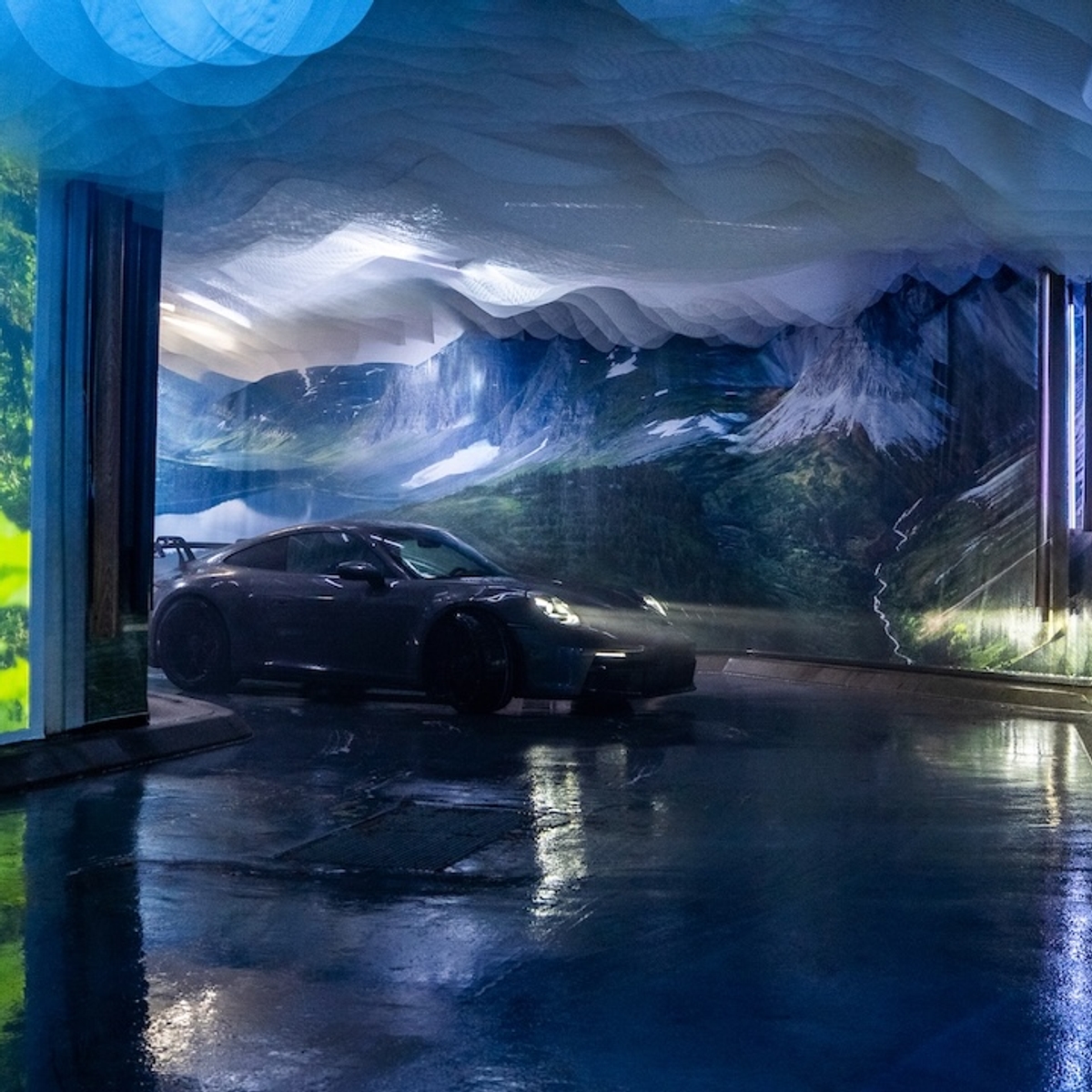 A car driving into a carwash that has been transformed into an immersive, interactive experience showcasing beautiful imagery from British Columbia.