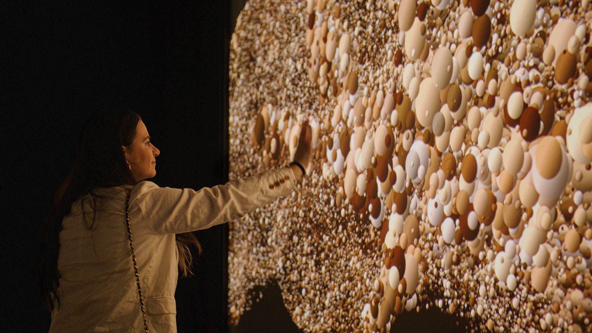 A women interacting with a responsive art exhibit.