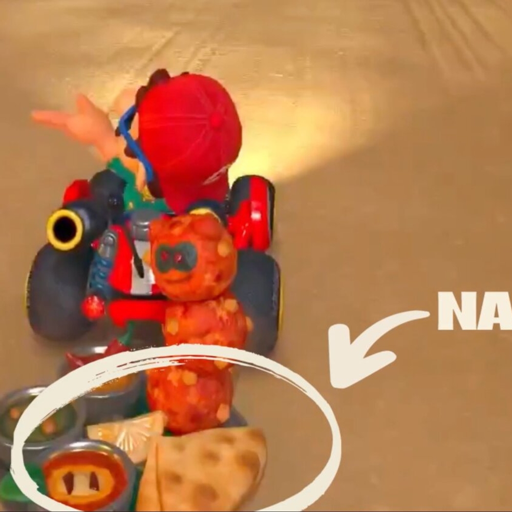 A video game character in a red hat is driving a go-kart.