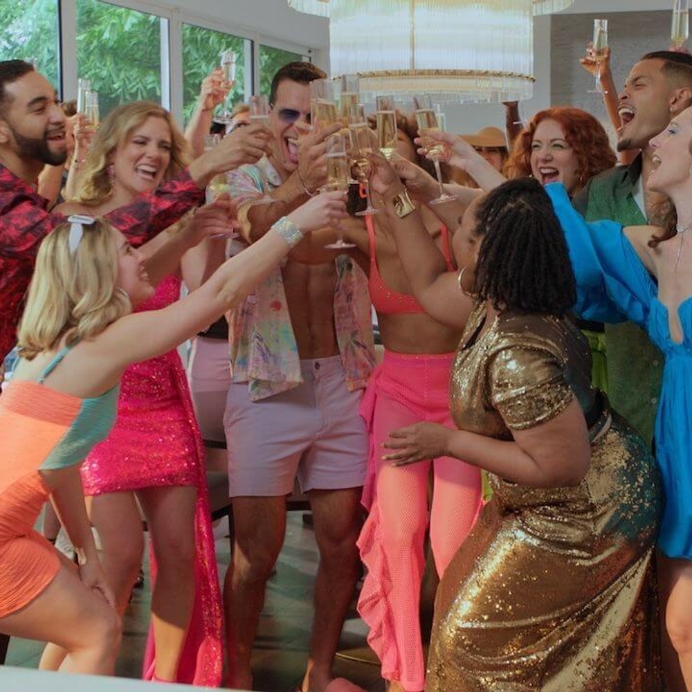 A group of attractive young people raising champagne glasses while celebrating.