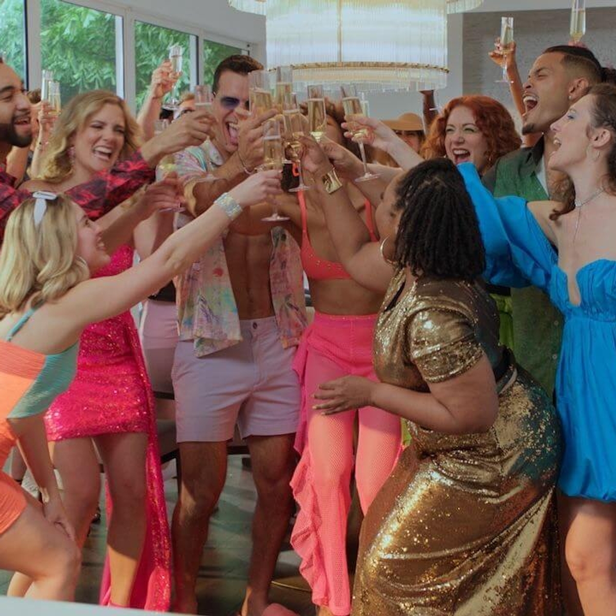 A group of attractive young people raising champagne glasses while celebrating.
