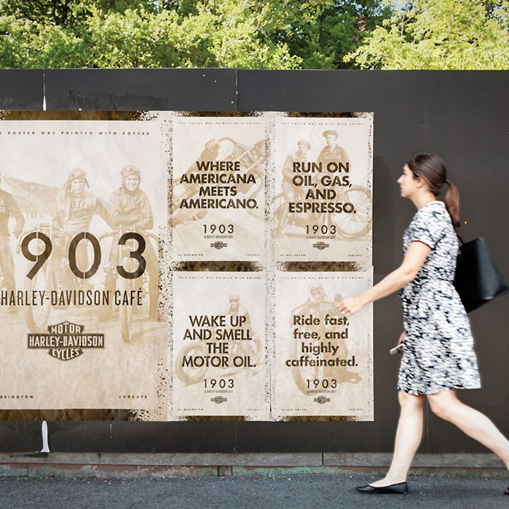 A woman walking past vintage-style wild postings advertising the café on the street.