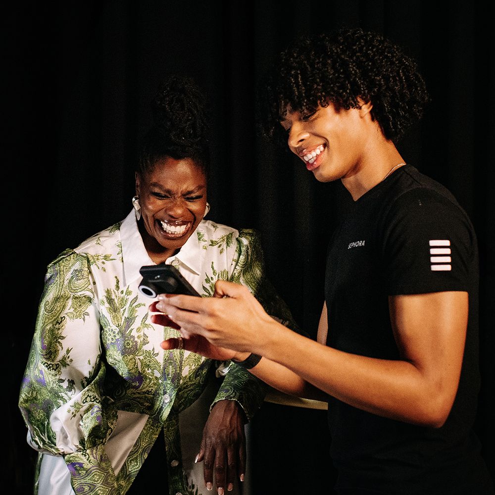 A man showing a women the results of her skin tone test on a phone.