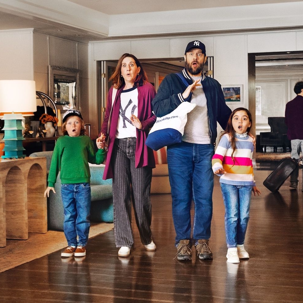 A son, mother, father and daughter stand in a room looking shocked