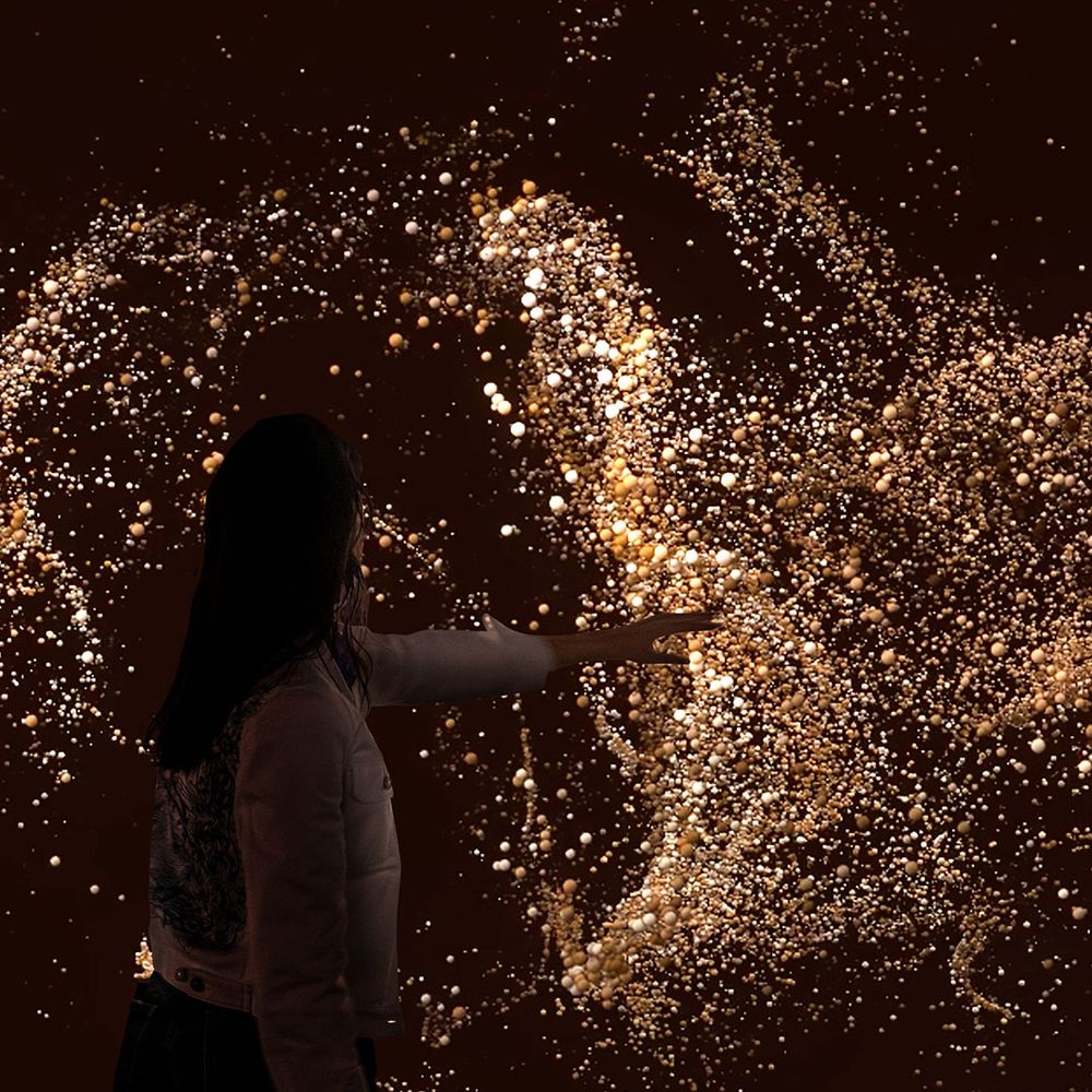 A women interacting with an immersive art exhibit.