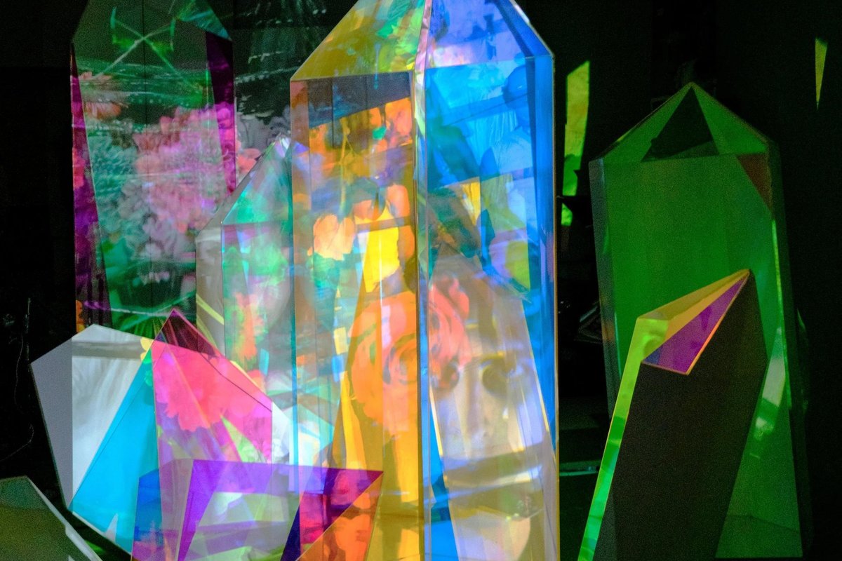 Crystal sculpture close-up with projected face and flowers