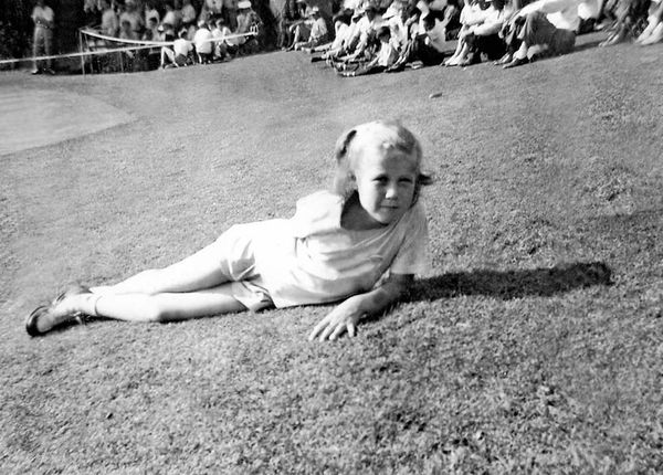 Young Marty lays in the grass at a golf event