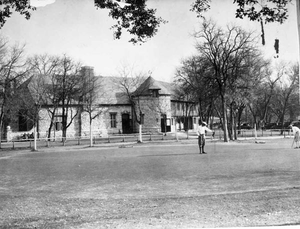 Early photo of the clubhouse and practice green of Brackenridge Park