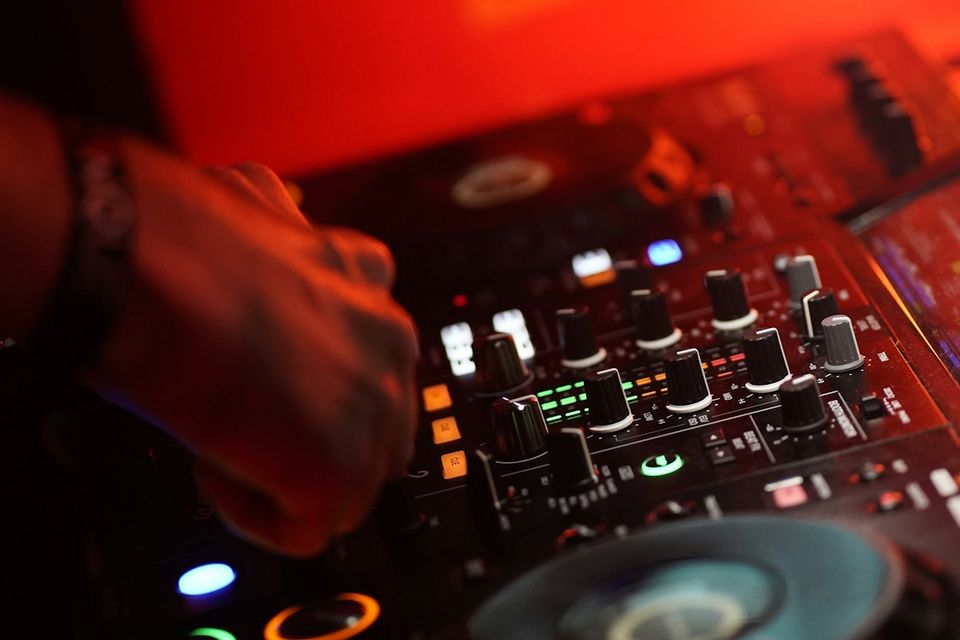 DJ mixer with screen glow in a dark studio setting