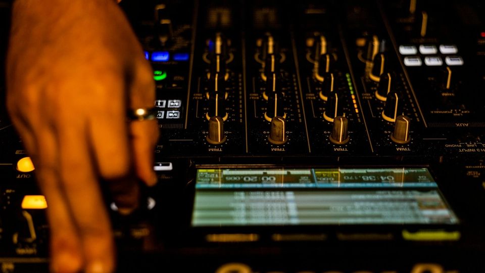 Hand on Pioneer DJM mixer faders