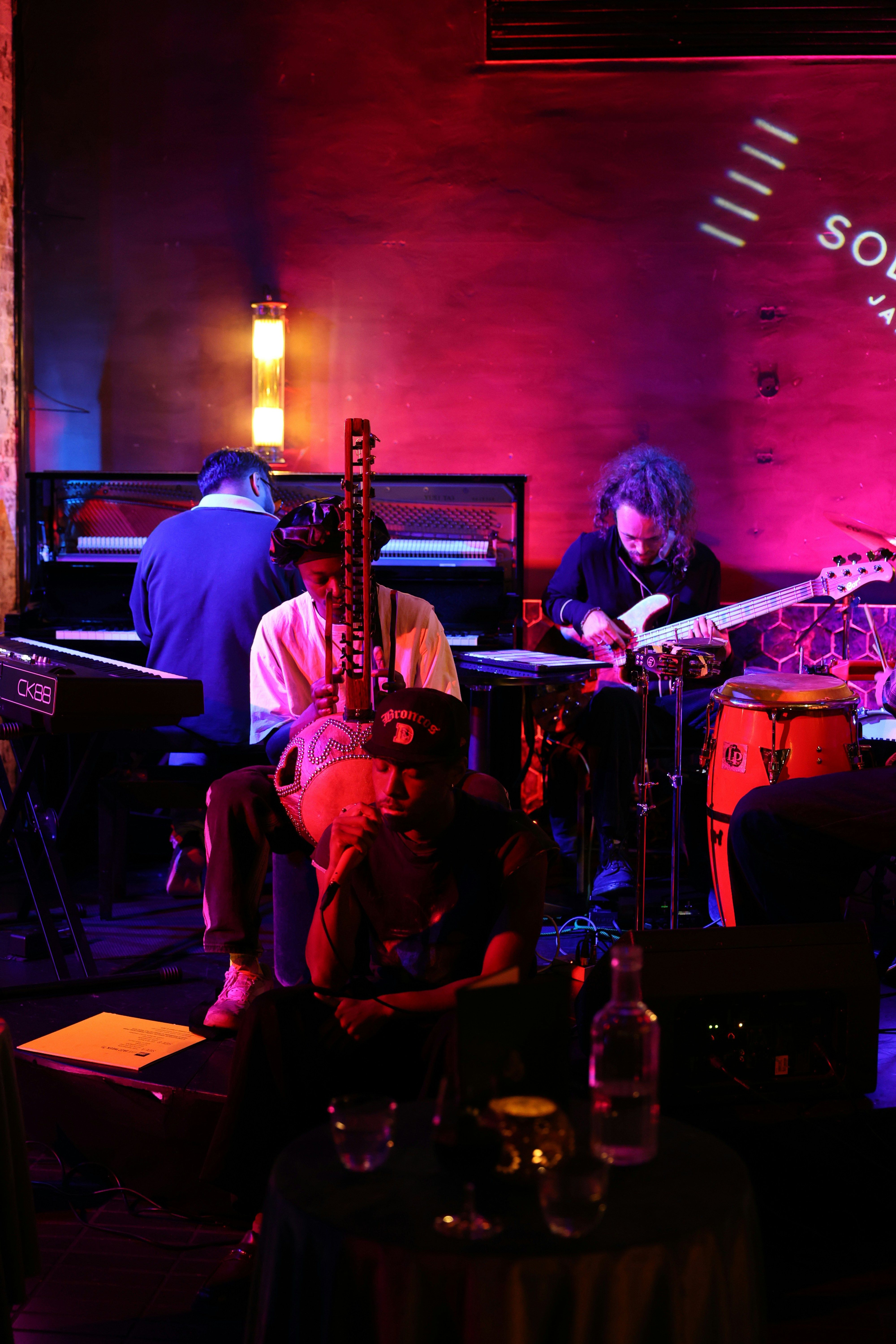 Musicians performing in a dimly lit jazz club with warm amber stage lighting