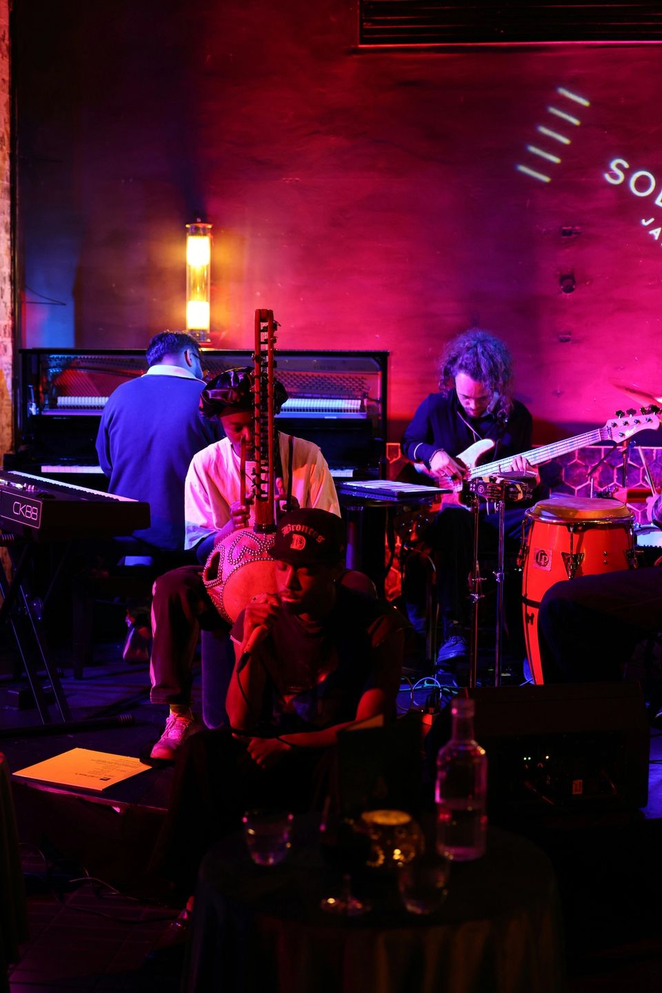 Musicians performing in a dimly lit jazz club with warm amber stage lighting