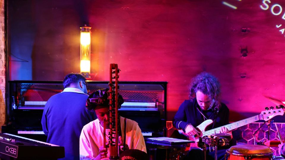 Musicians performing in a dimly lit jazz club with warm amber stage lighting