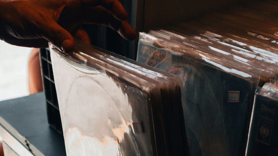Hand flipping through vinyl records