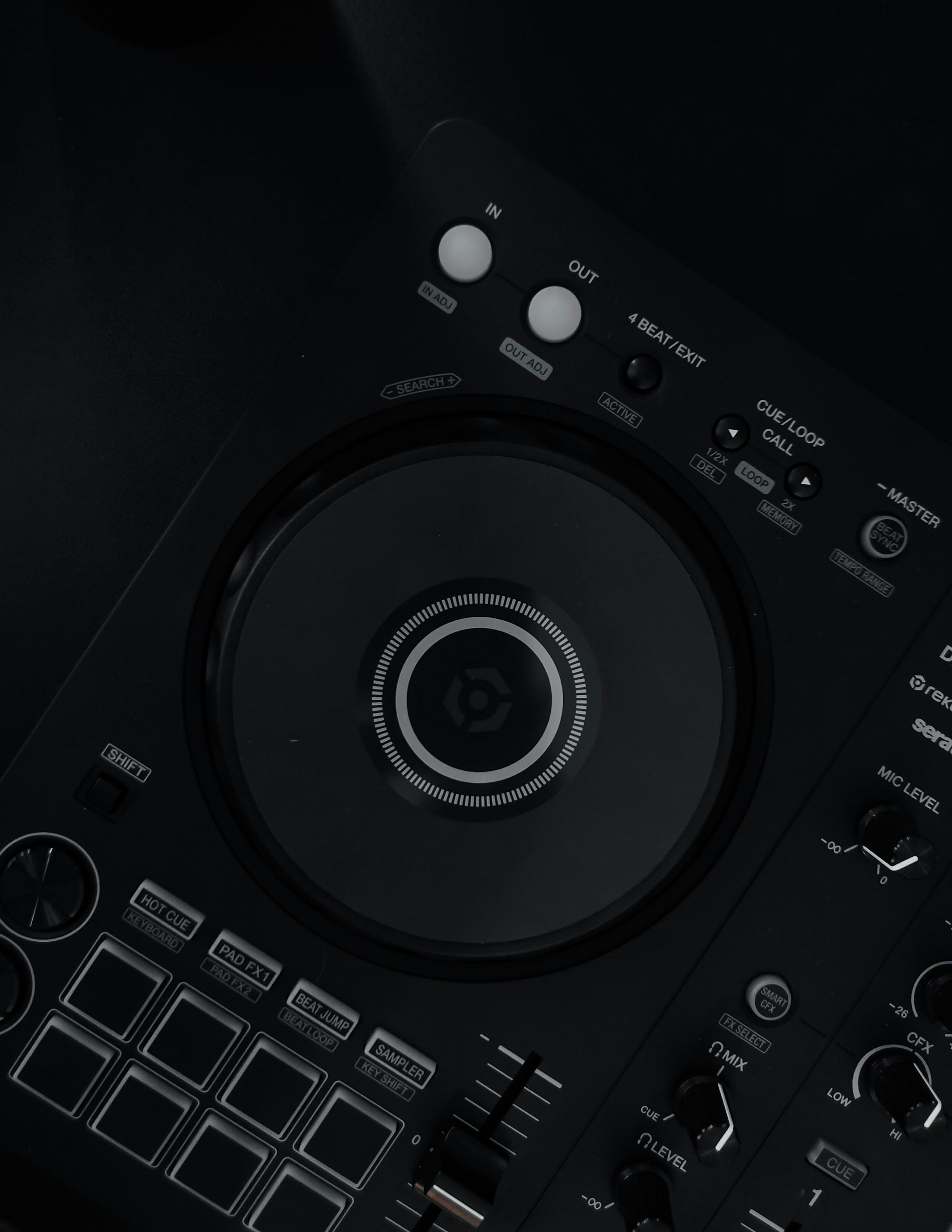 A close-up of a DJ controller on a dark surface with no laptop in frame
