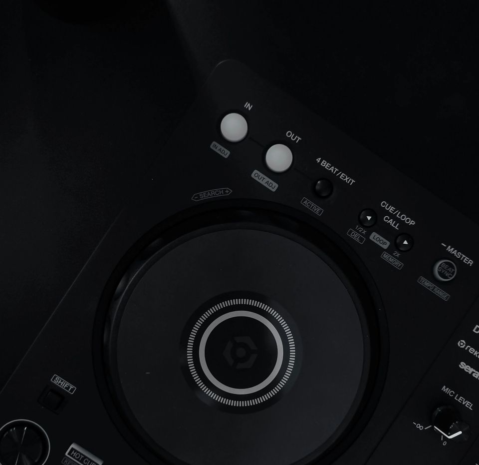 A close-up of a DJ controller on a dark surface with no laptop in frame