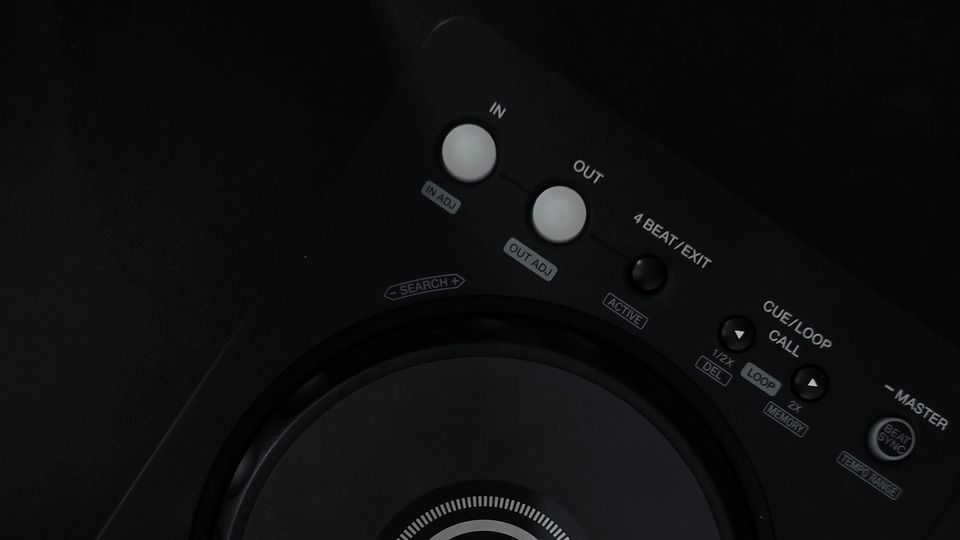 A close-up of a DJ controller on a dark surface with no laptop in frame