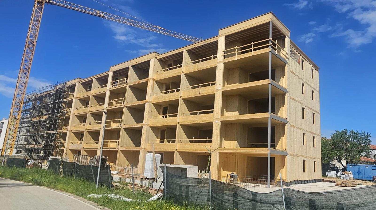 Residence Moela u Umagu — pogled na suvremeni stambeni kompleks s drvenom CLT konstrukcijom u izgradnji, projekt arhitektonskog studija IVN Architecture.