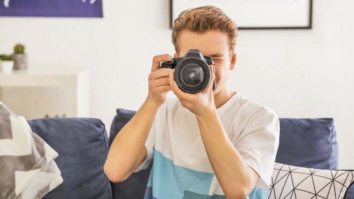 подросток держит фотоаппарат и фокусируется
